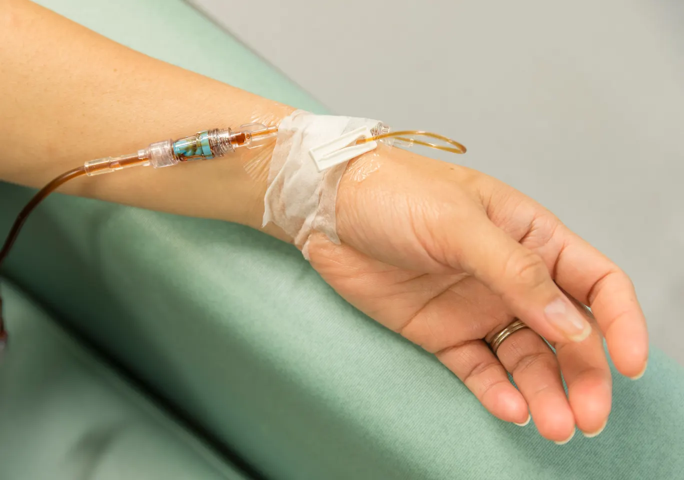 Kroplówki witaminowe Kraśnik: dłoń z wenflonem i linią infuzyjną na podkładzie